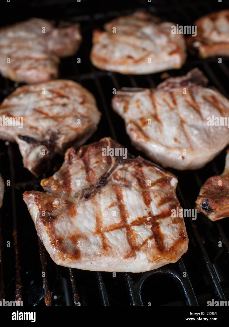 Chuletas de cerdo a la parrilla de cocción Fotografía de stock - Alamy