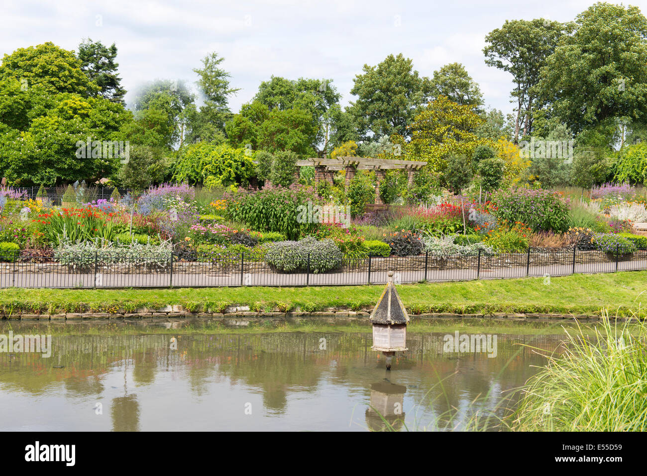 North West London Golders Hill Park Lily Pond lago de agua, casita para aves y jardines en árboles de flores de verano naturaleza gazebo escena Foto de stock