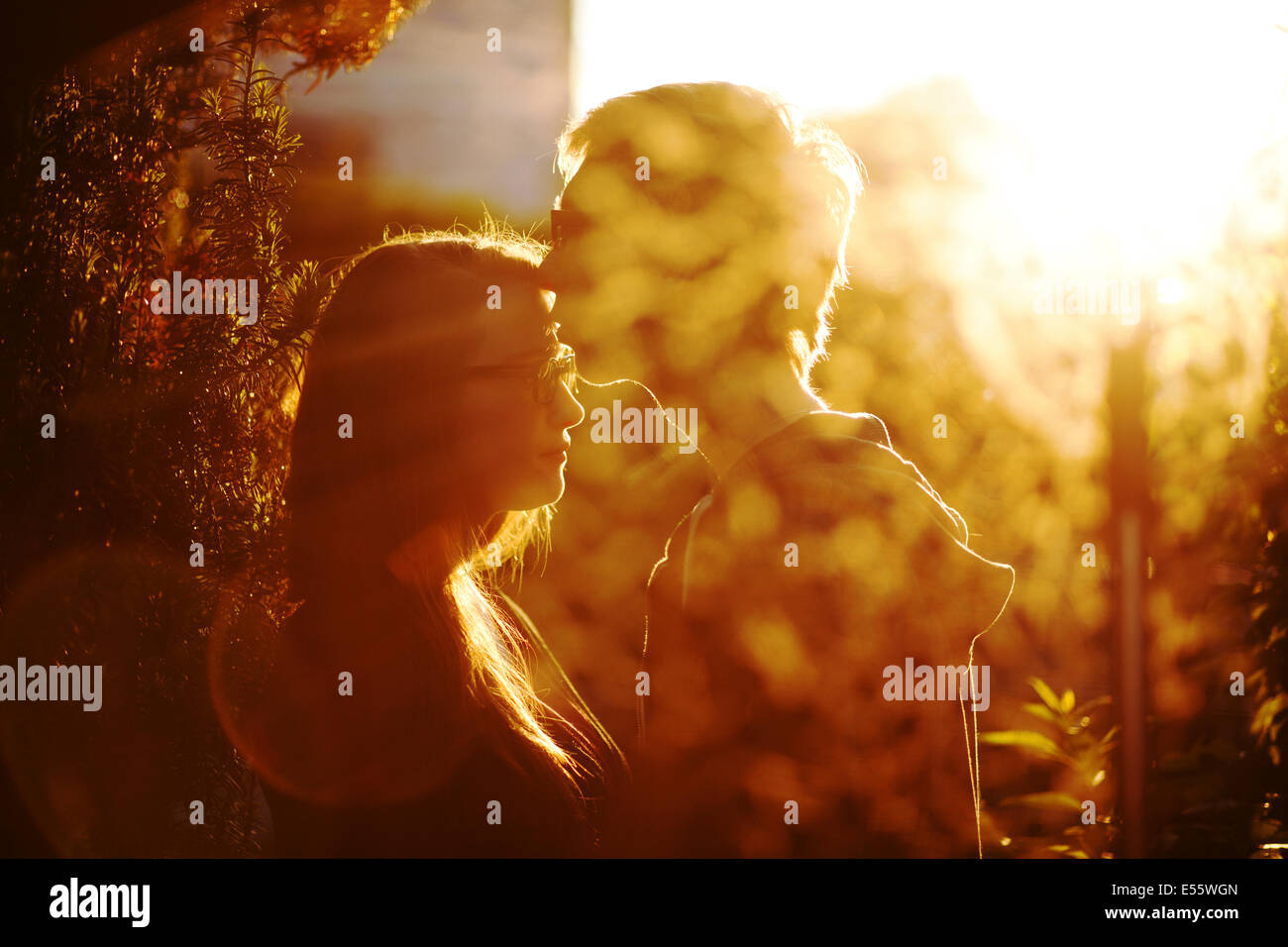 Pareja joven en amor besar con luz de fondo Foto de stock