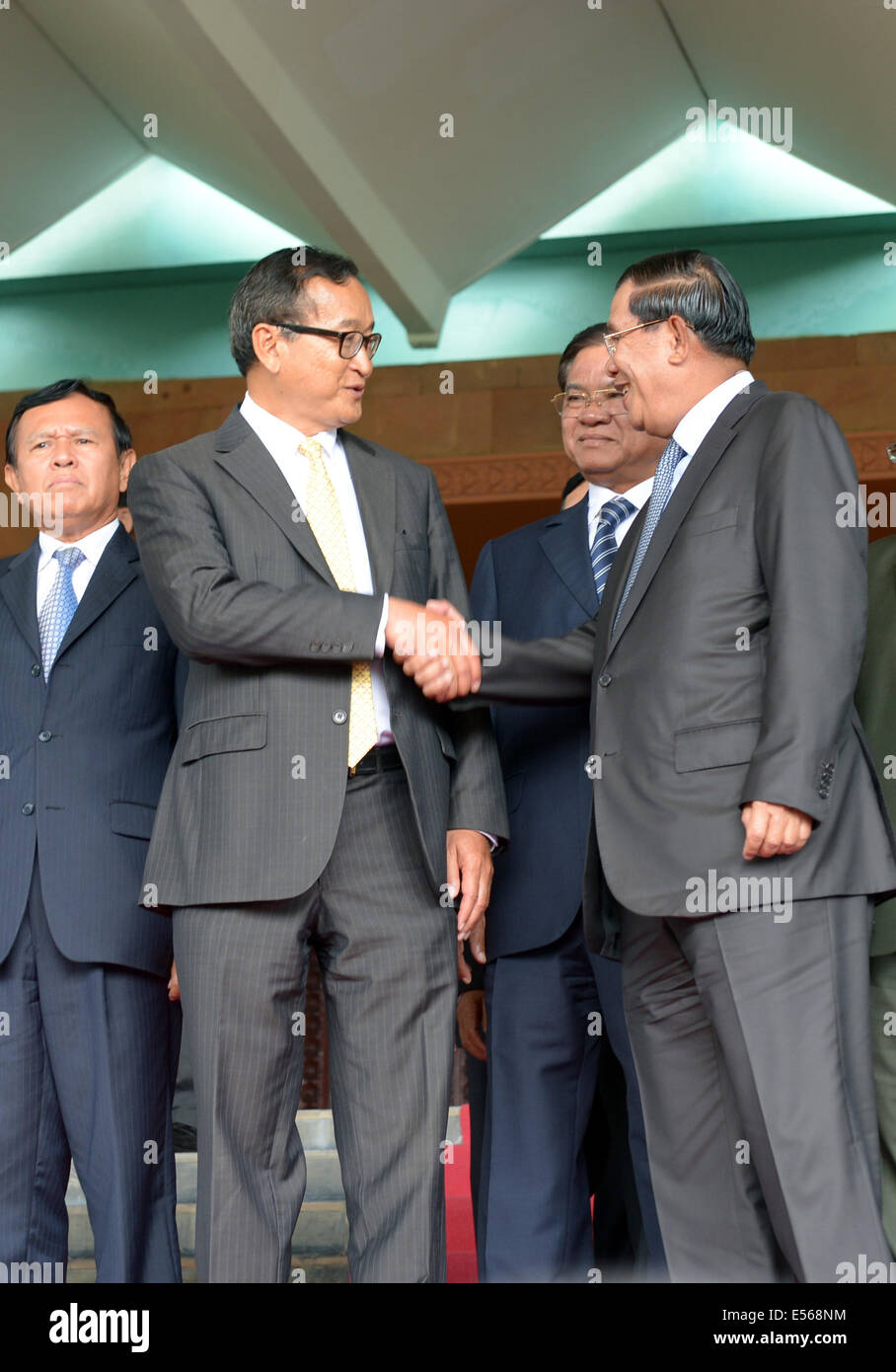 Phnom Penh, Camboya. El 22 de julio de 2014. Primer Ministro de Camboya Hun Sen (R, delantero) se da la mano con Sam Rainsy (L, delantero), Presidente de la oposición Partido Rescate Nacional de Camboya, en Phnom Penh, Camboya, 22 de julio de 2014. La oposición del Partido Rescate Nacional de Camboya (CNRP) el martes acordaron poner fin a sus largos años de boicotear el parlamento después de que el partido gobernante acordó reformas electorales, el reparto de poder en el parlamento y una licencia de TV. Crédito: Sovannara/Xinhua/Alamy Live News Foto de stock