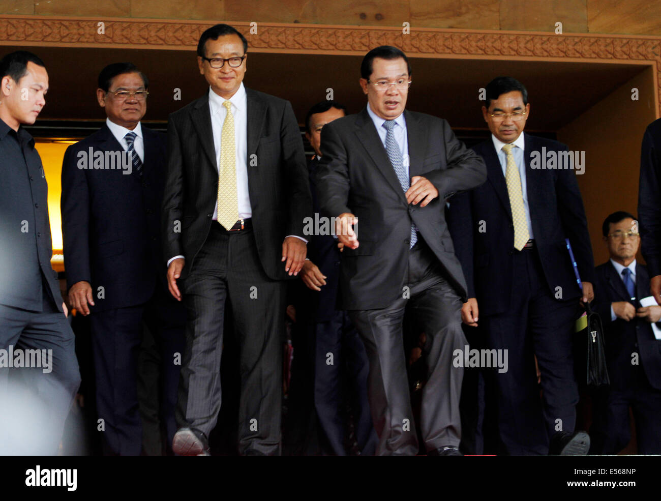 Phnom Penh, Camboya. El 22 de julio de 2014. Primer Ministro de Camboya Hun Sen (R, delantero) y Sam Rainsy (L, delantero), Presidente de la oposición Partido Rescate Nacional de Camboya, salir de una sala de reunión en Phnom Penh, Camboya, 22 de julio de 2014. La oposición del Partido Rescate Nacional de Camboya (CNRP) el martes acordaron poner fin a sus largos años de boicotear el parlamento después de que el partido gobernante acordó reformas electorales, el reparto de poder en el parlamento y una licencia de TV. Crédito: Sovannara/Xinhua/Alamy Live News Foto de stock