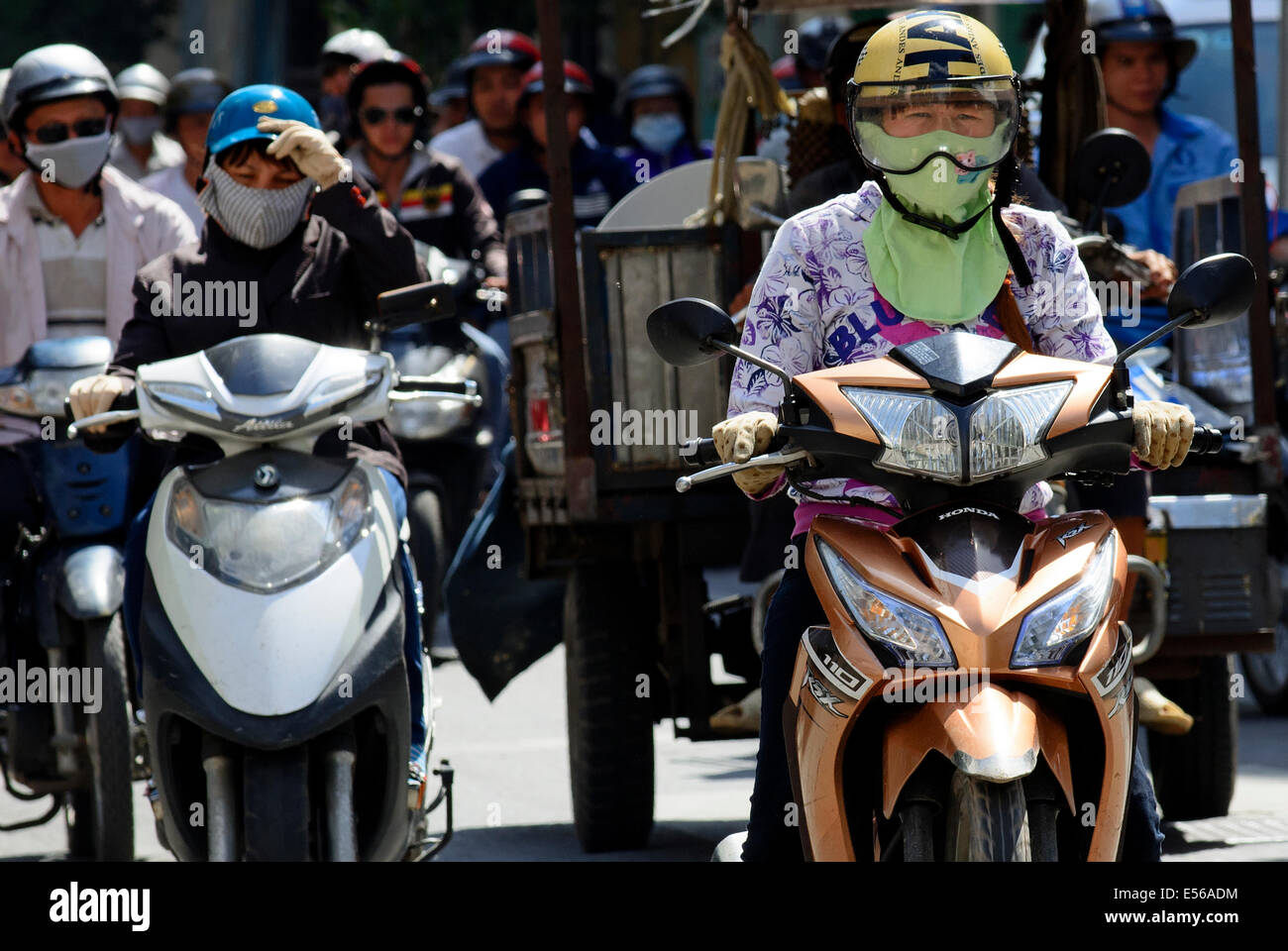 Viajeros con motocicletas y portando máscaras de contaminación, Ho Chi Minh, Vietnam. Foto de stock