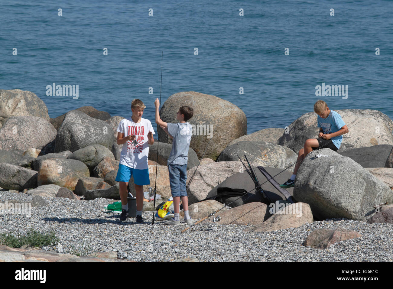 Muchachos adolescentes disfrutando de sus vacaciones de verano en el sonido, angulación Oresund, desde el punto de Kronborg en Helsingør / Elsinor. Foto de stock