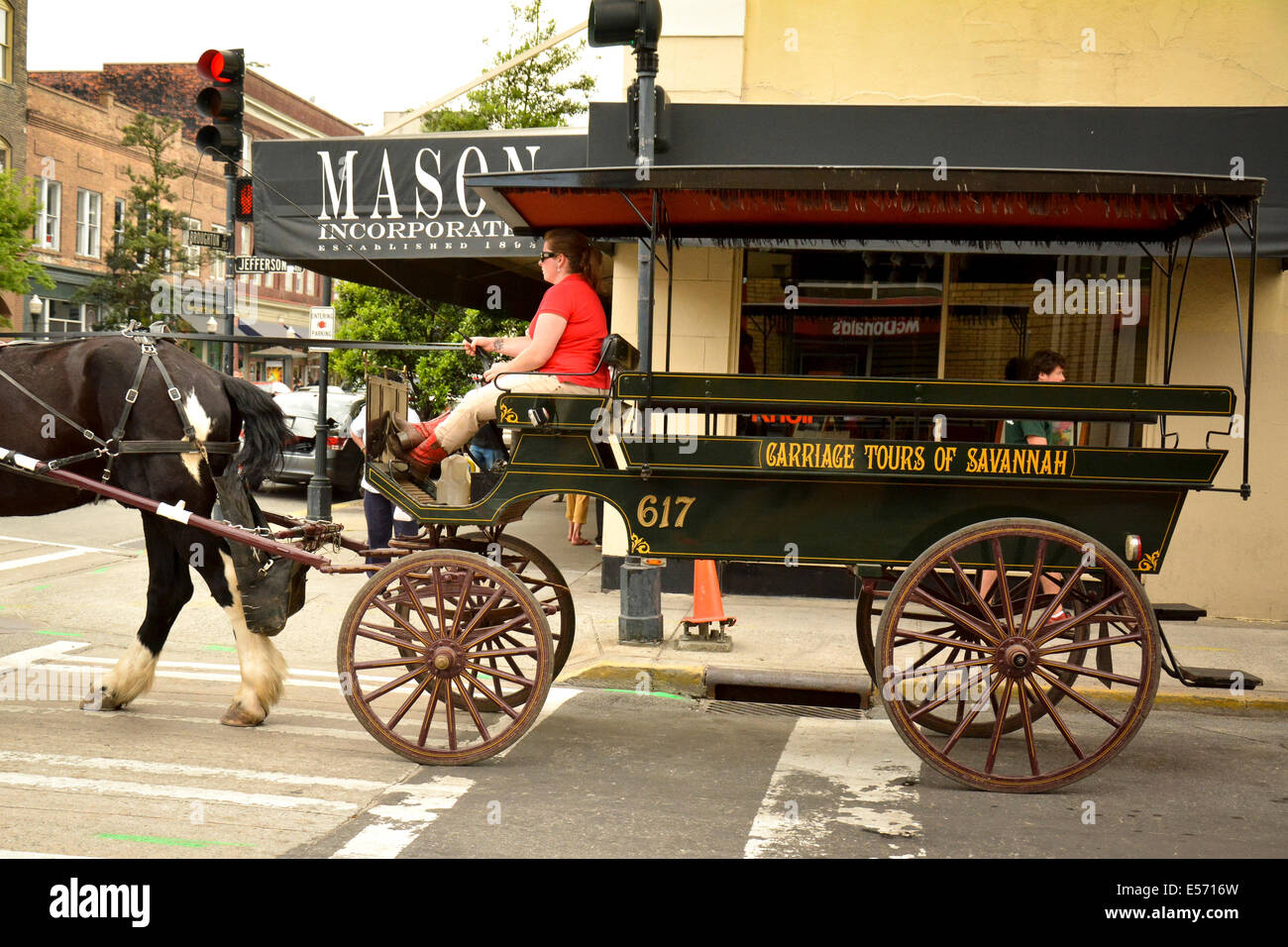 Un carruaje tirado por caballos para paseos turísticos y Jefferson Broughton cruza calles en el centro histórico de Savannah, GA, EE.UU. Foto de stock