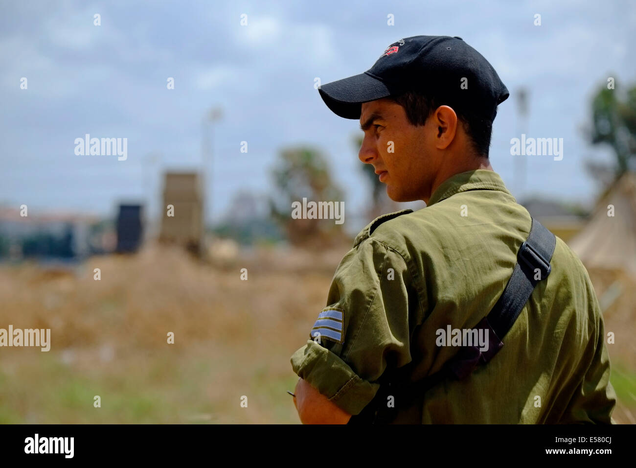 Un soldado israelí con el dispositivo anti misiles israelíes en el fondo que se llama la cúpula de hierro cerca de Yahud en Israel Foto de stock