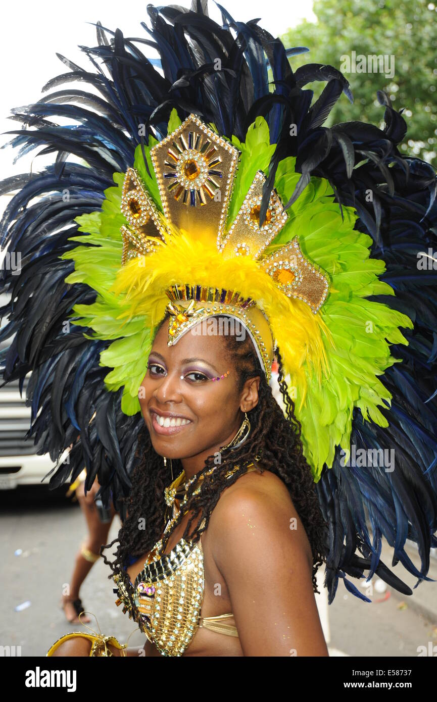 Fotografía de una joven mujer en el Carnaval de Notting Hill vistiendo tradicionales Caribe tocado de plumas Foto de stock