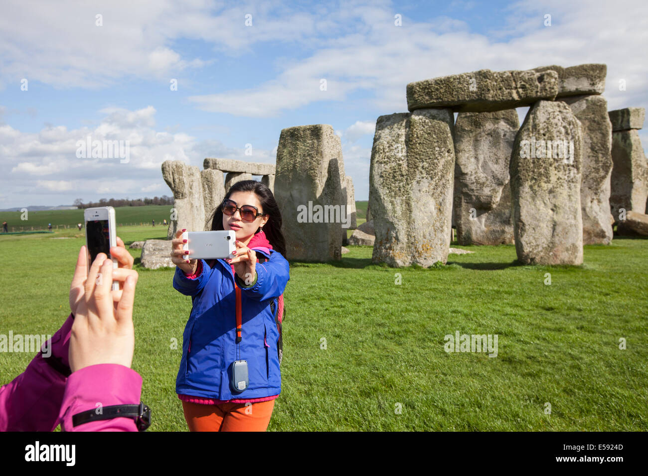 Los turistas fotografiar y las piedras al pie círculo de piedra de Stonehenge, Wiltshire, UK Foto de stock