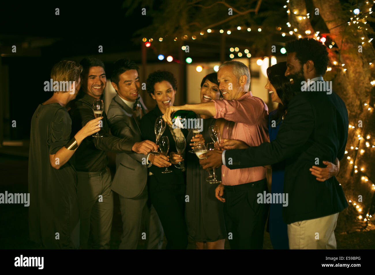 Amigos celebrando con champán en parte Foto de stock