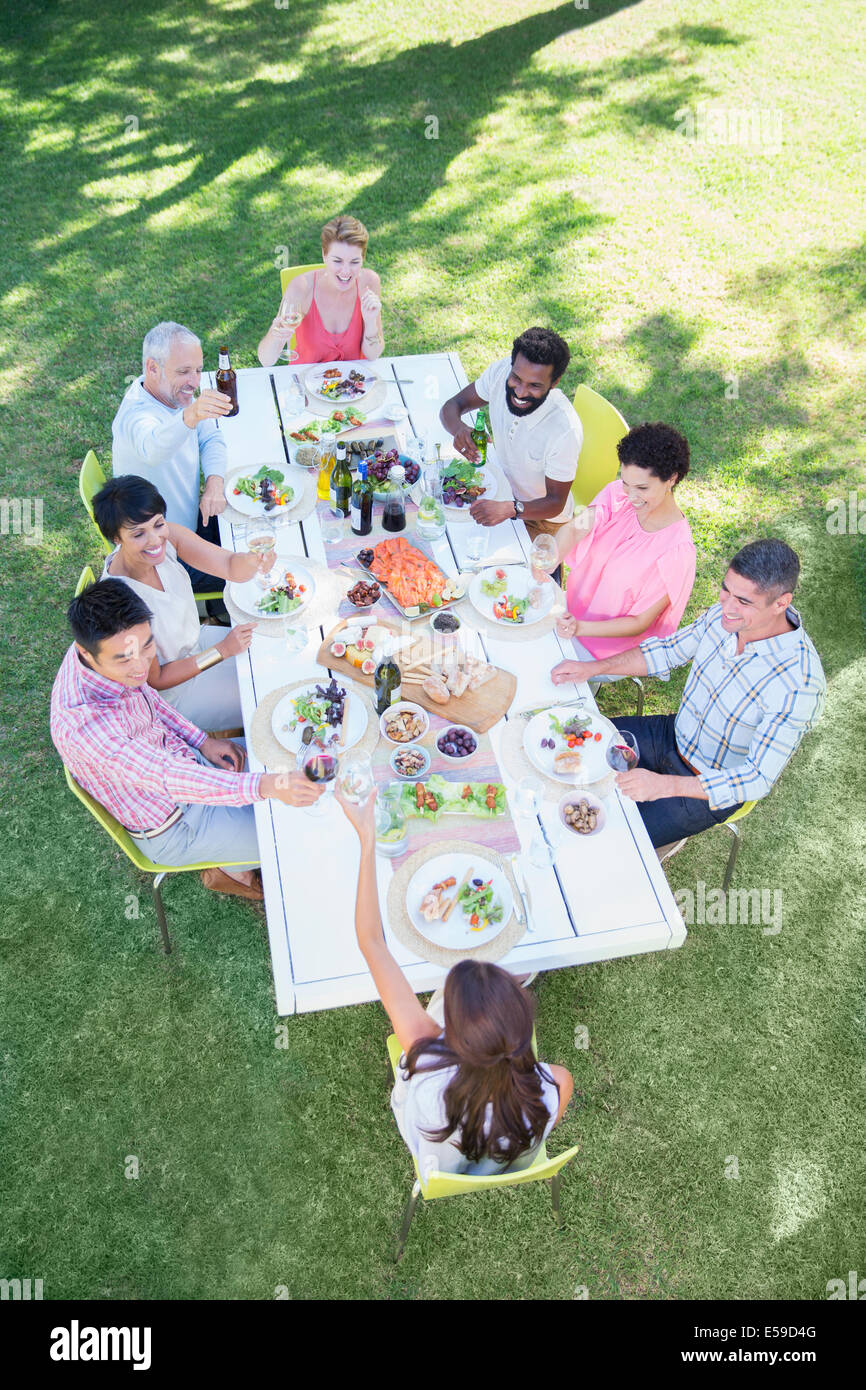 Amigos comiendo juntos en la mesa al aire libre Foto de stock
