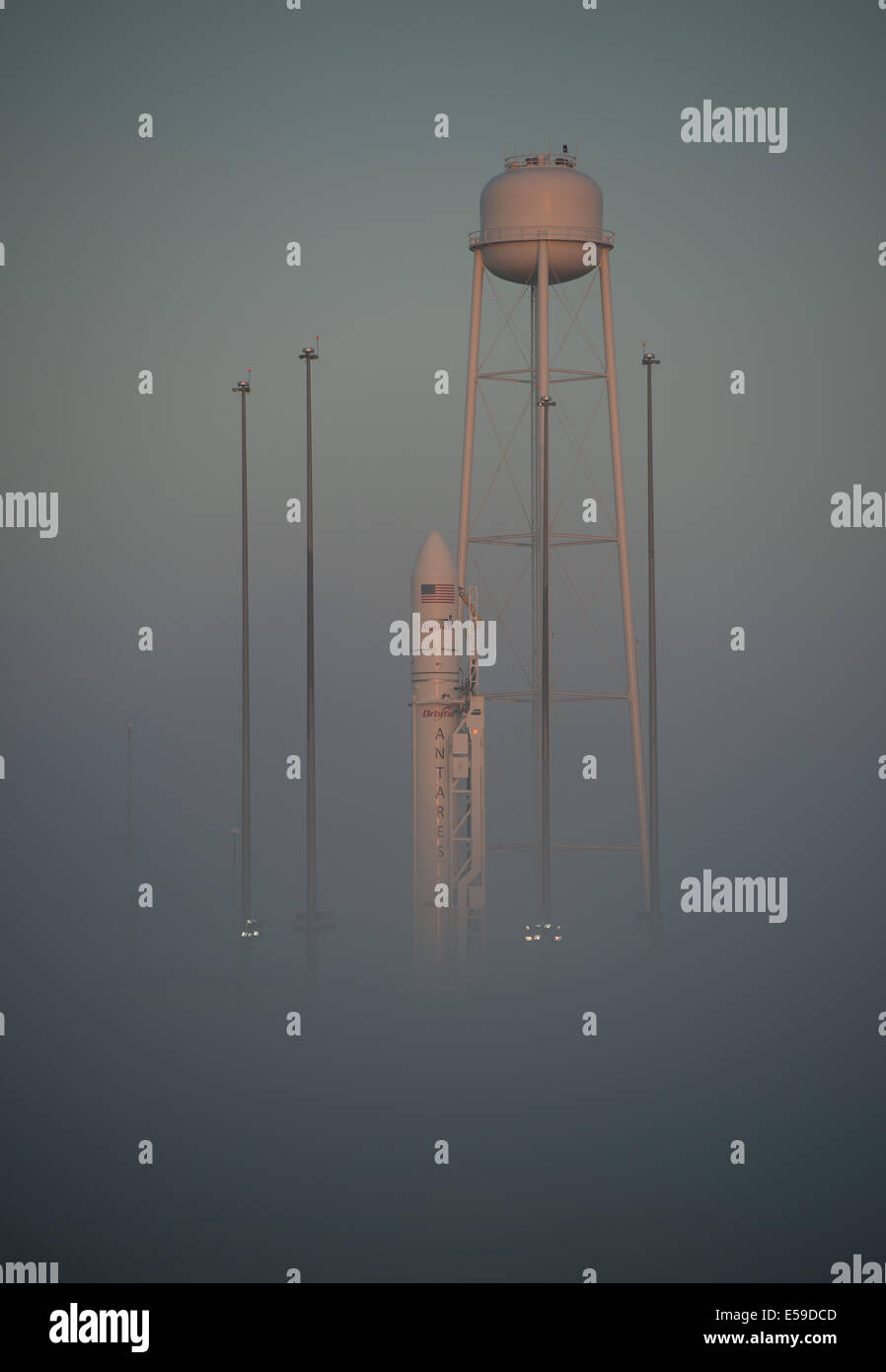 La Orbital Sciences Corporation, con el cohete Antares Cygnus a bordo de naves espaciales, es visto en la niebla de la mañana, sábado, 12 de julio de 2014, en Launch Pad-0A de la NASA Wallops Flight Facility en Virginia. El Antares se lanzará con la nave Cygnus fi Foto de stock