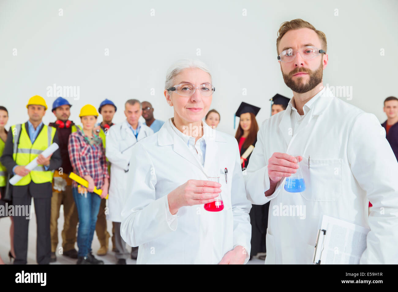Retrato de los científicos con los trabajadores en segundo plano. Foto de stock