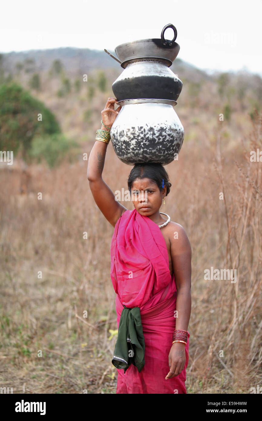 Mujer Tribal llevar utensilios en su cabeza, Kamar tribu, Aldea, Chattisgadh Matal, India Foto de stock