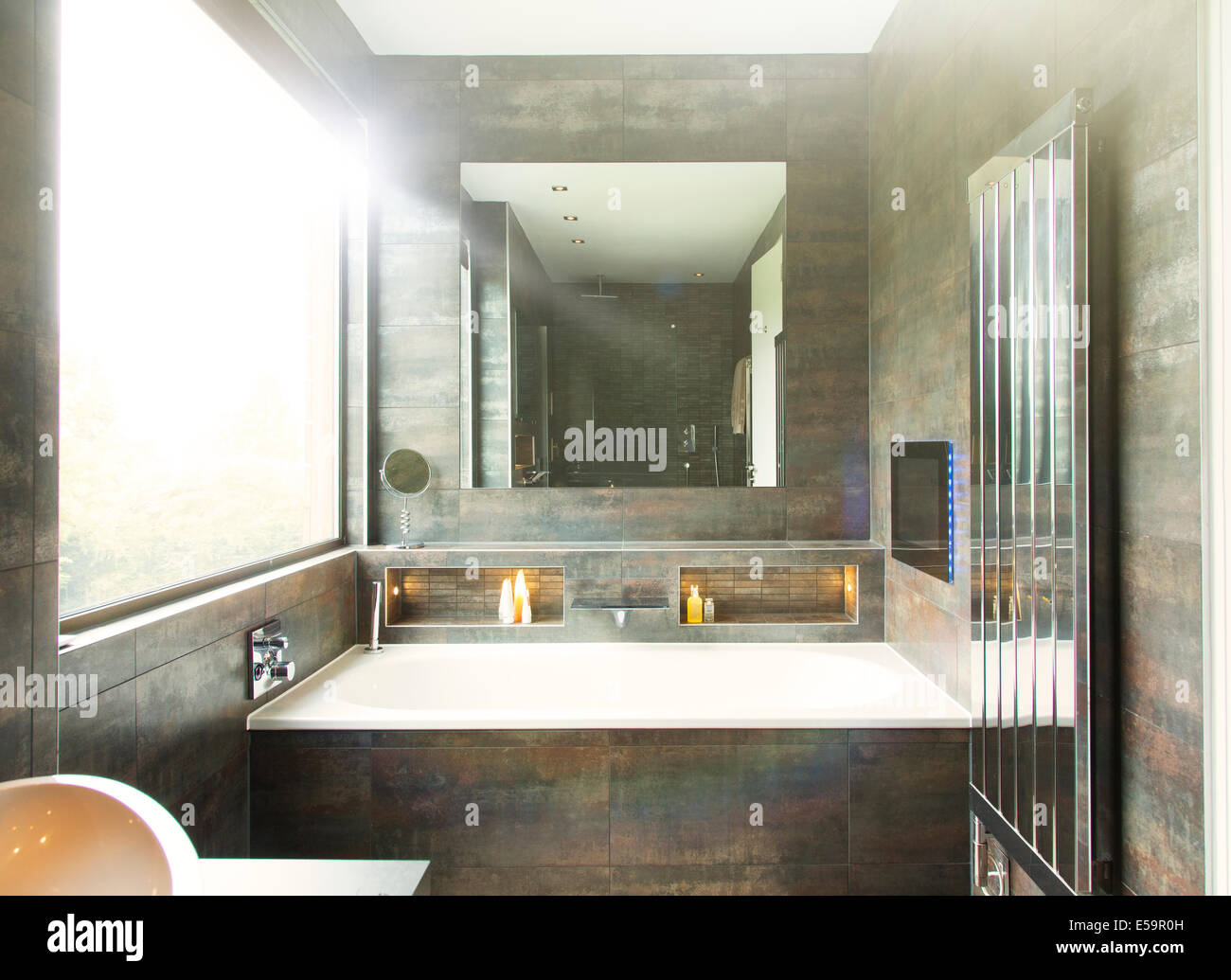 Bañera y espejo en el cuarto de baño moderno Foto de stock