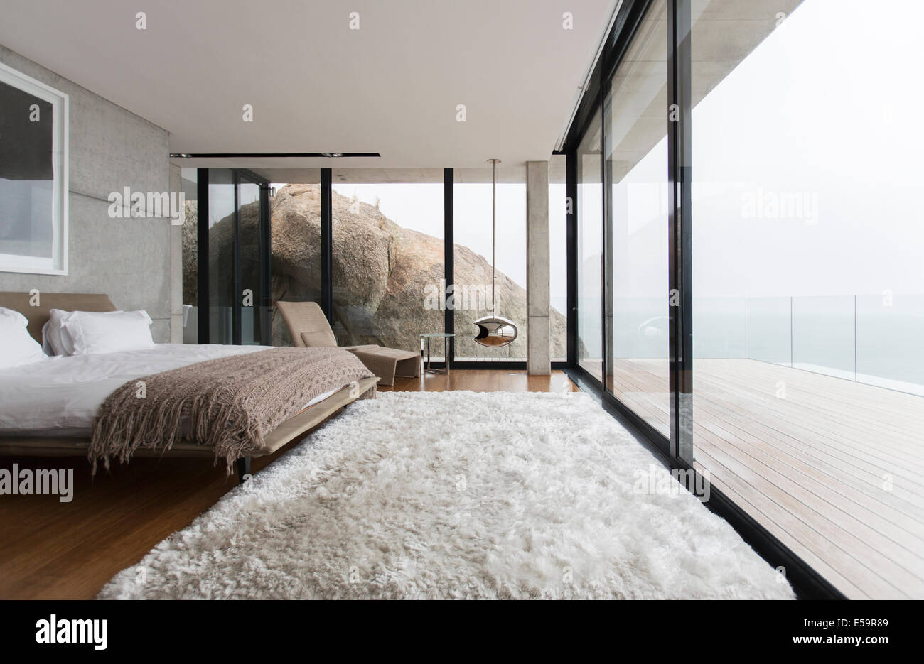 Shag rug y paredes de vidrio en dormitorio moderno Foto de stock