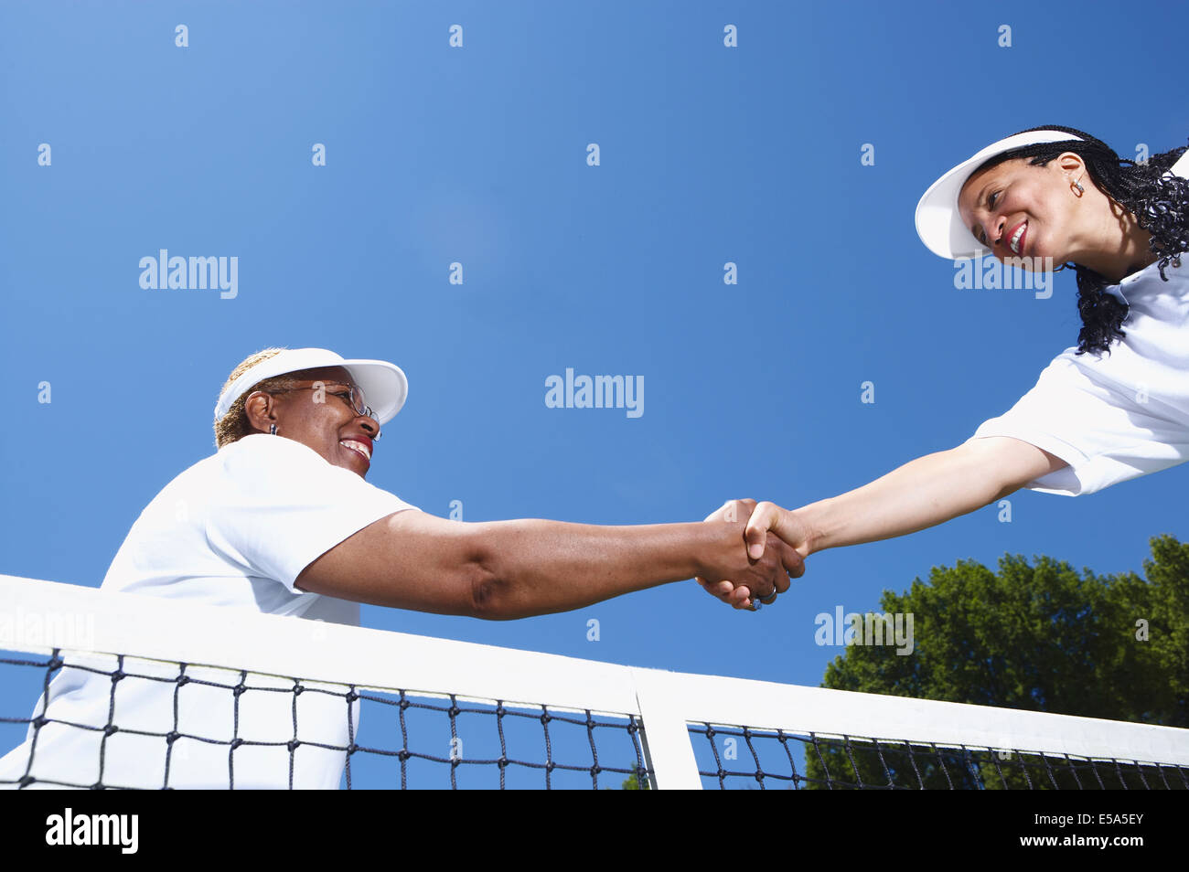 Los jugadores de tenis se estrechan las manos en net Foto de stock