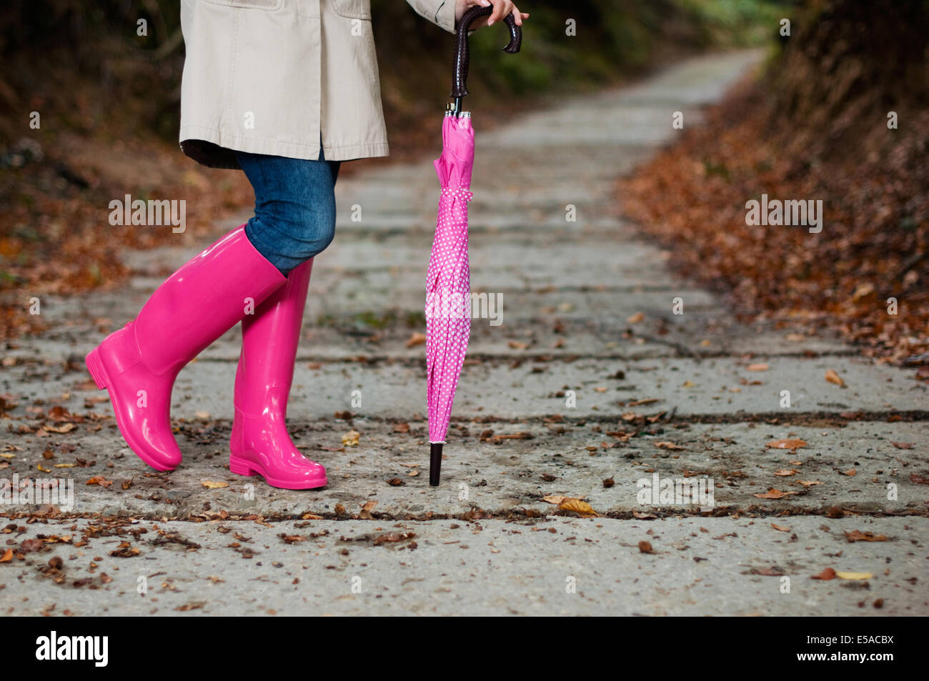 Mujer joven con chubasquero amarillo y botas de goma en la naturaleza  primaveral Fotografía de stock - Alamy