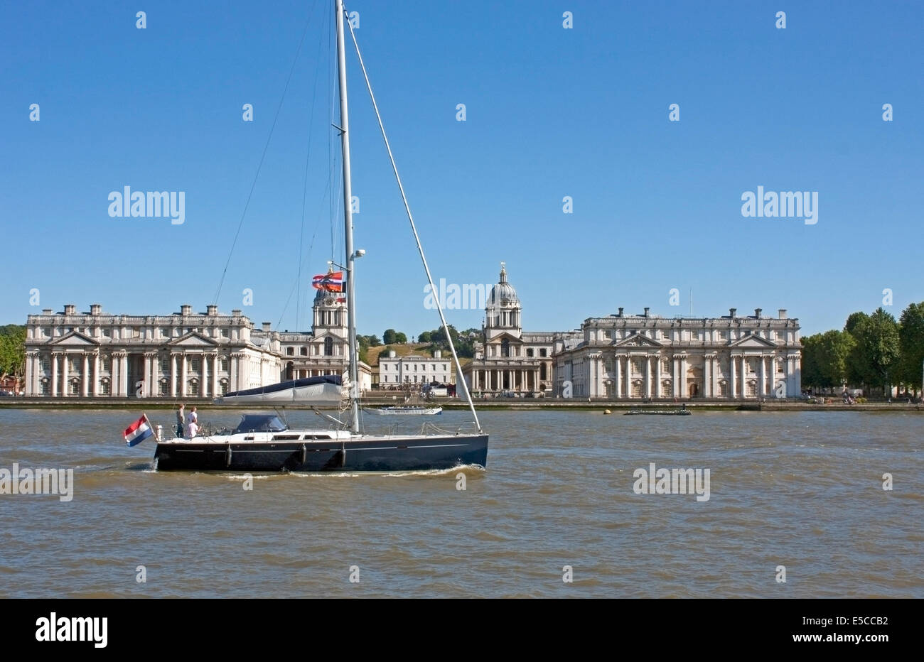 Un Yate pasando junto al antiguo Colegio Naval en la orilla sur del Támesis en Greenwich, Londres, diseñado por Sir Christopher Wren Foto de stock