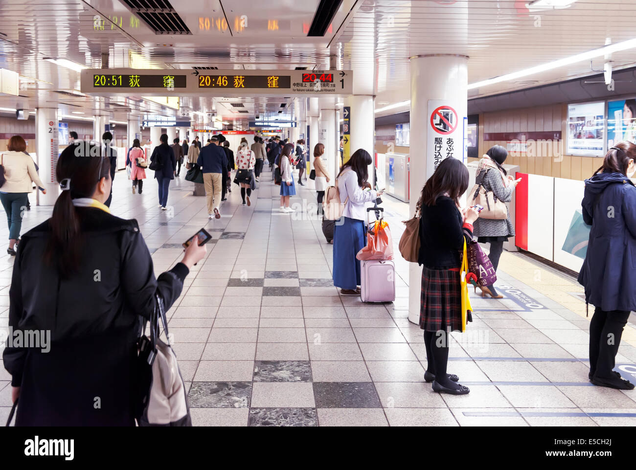 Las personas que esperan un tren en una plataforma de la estación de metro de Tokio. Tokio, Japón. Foto de stock