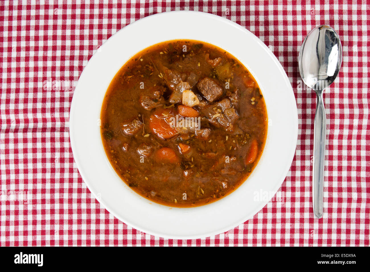 Sopa Goulash en la cubeta de la accidentada mantel blanco Foto de stock