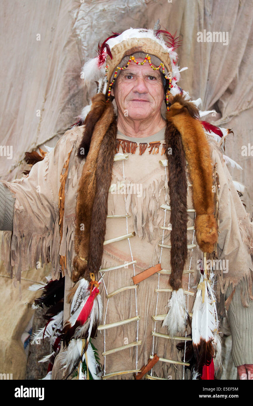 Un residente local, vistiendo ropa americana nativa tradicional saluda a la línea de cruceros de pasajeros.Saguanay,Canadá Foto de stock