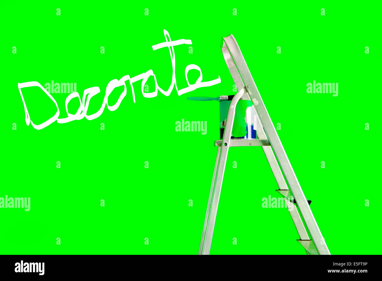 Decorar escrito sobre una pared verde con una escalera de tijera,una lata de pintura y un pincel Foto de stock