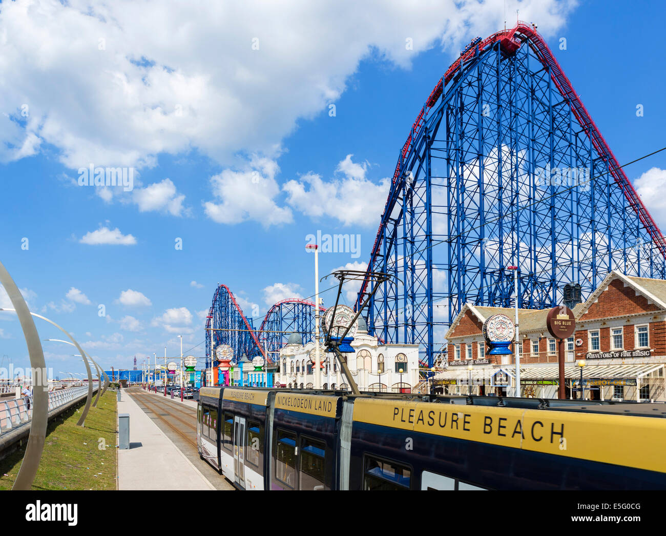 El tranvía en el Paseo Maritimo enfrente de la gran montaña rusa en el parque de atracciones Pleasure Beach, Blackpool, Lancashire, UK Foto de stock