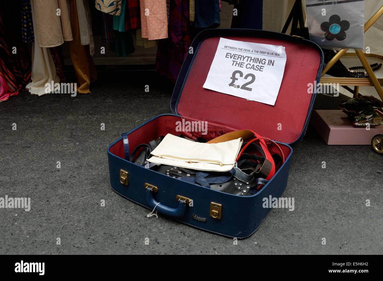 Una maleta con artículos de segunda mano a un precio de £2 sobre el terreno en un puesto el mercado al aire libre en Glasgow, Escocia, Reino Unido Fotografía de