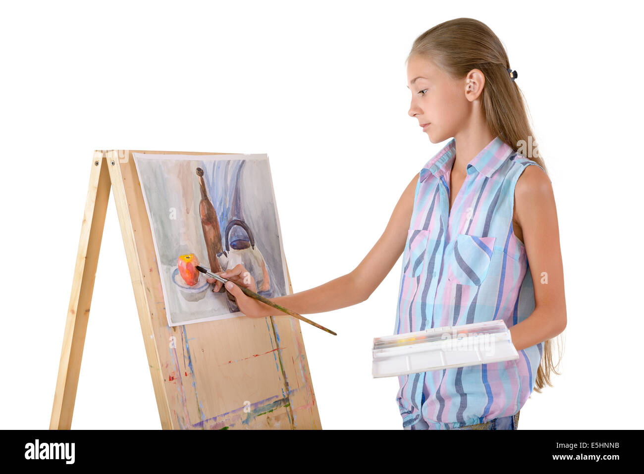 La niña dibuja sobre un caballete Foto de stock
