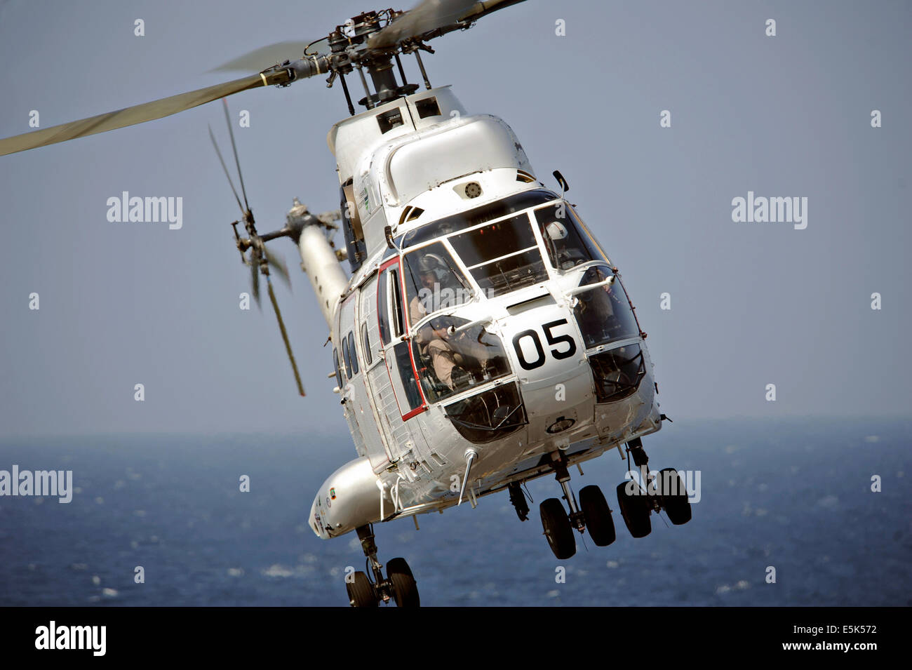Una US Navy SA-330J helicóptero Puma ferries carga del transporte marítimo de carga seca de comandos militares y municiones buque USNS César Chávez a la cubierta de vuelo del portaaviones USS Nimitz durante una reposición en alta mar el 12 de noviembre de 2013 en el Golfo de Adén. Foto de stock