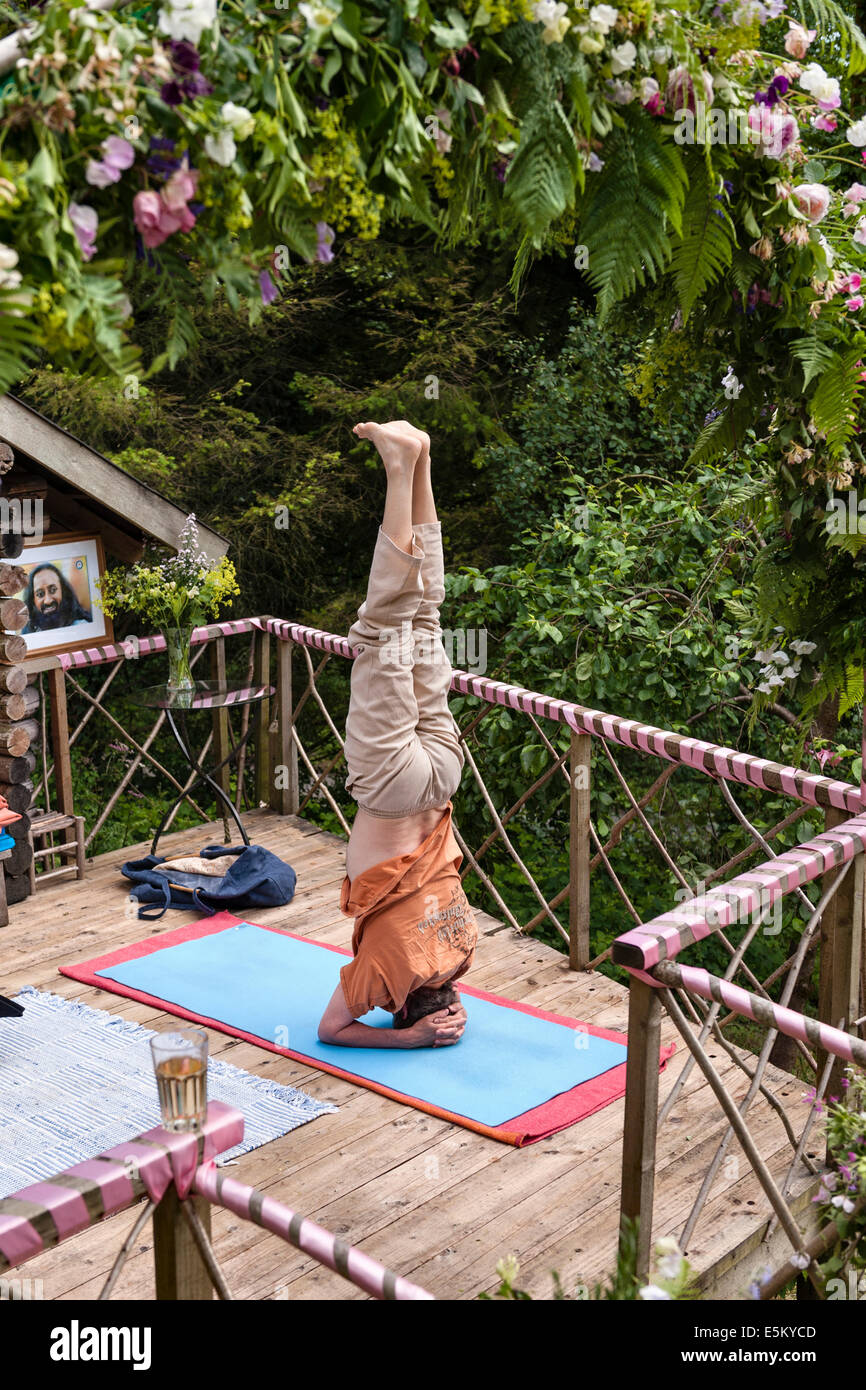 Un hombre de pie sobre su cabeza en un retiro de yoga Foto de stock