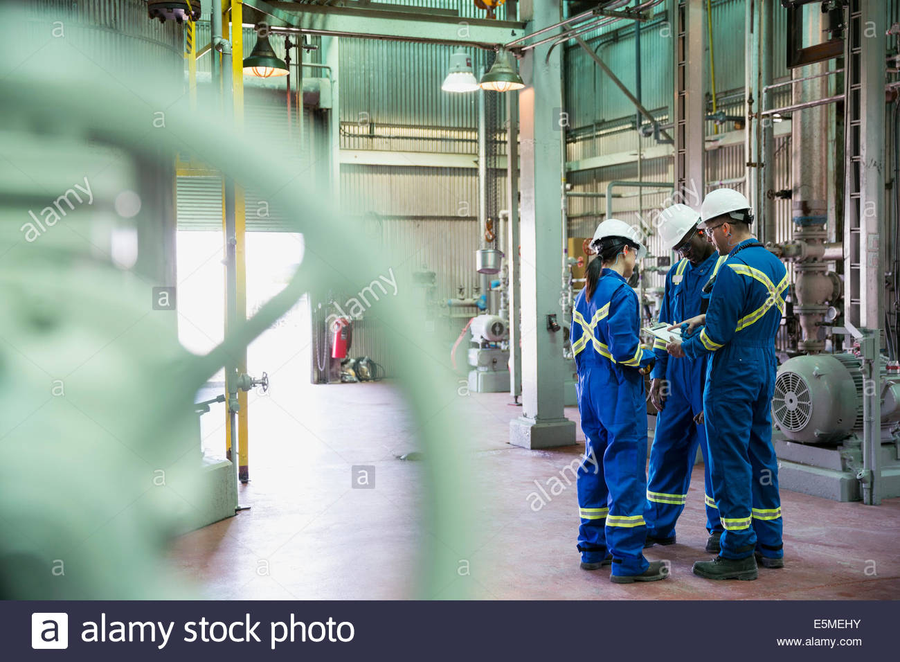 Los trabajadores revisando el papeleo en planta de gas Foto de stock