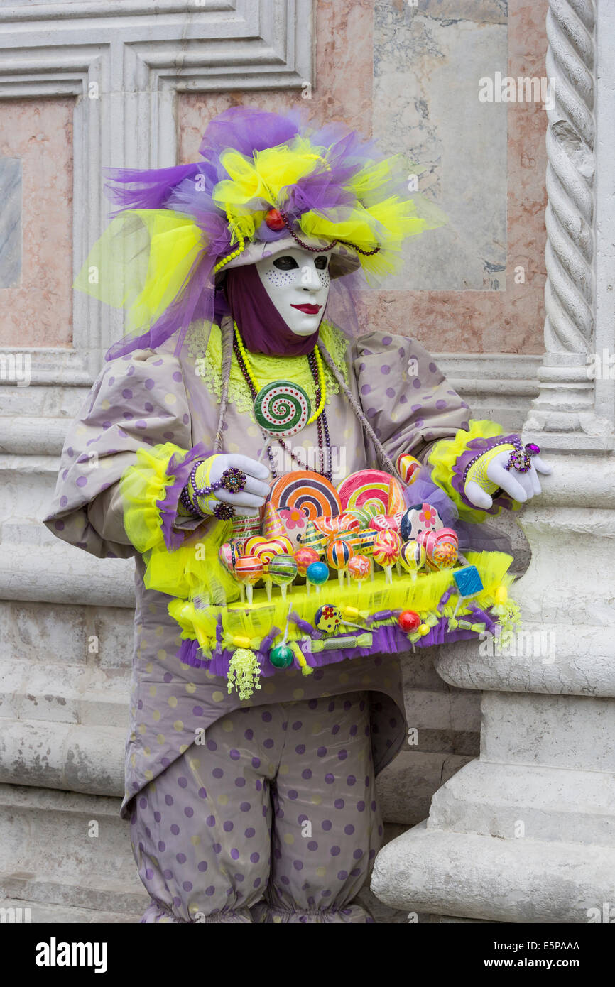 Candy vendedor disfraces hombre de lavanda y verde delante de la iglesia de  San Zaccaria durante el Carnaval en Venecia Fotografía de stock - Alamy