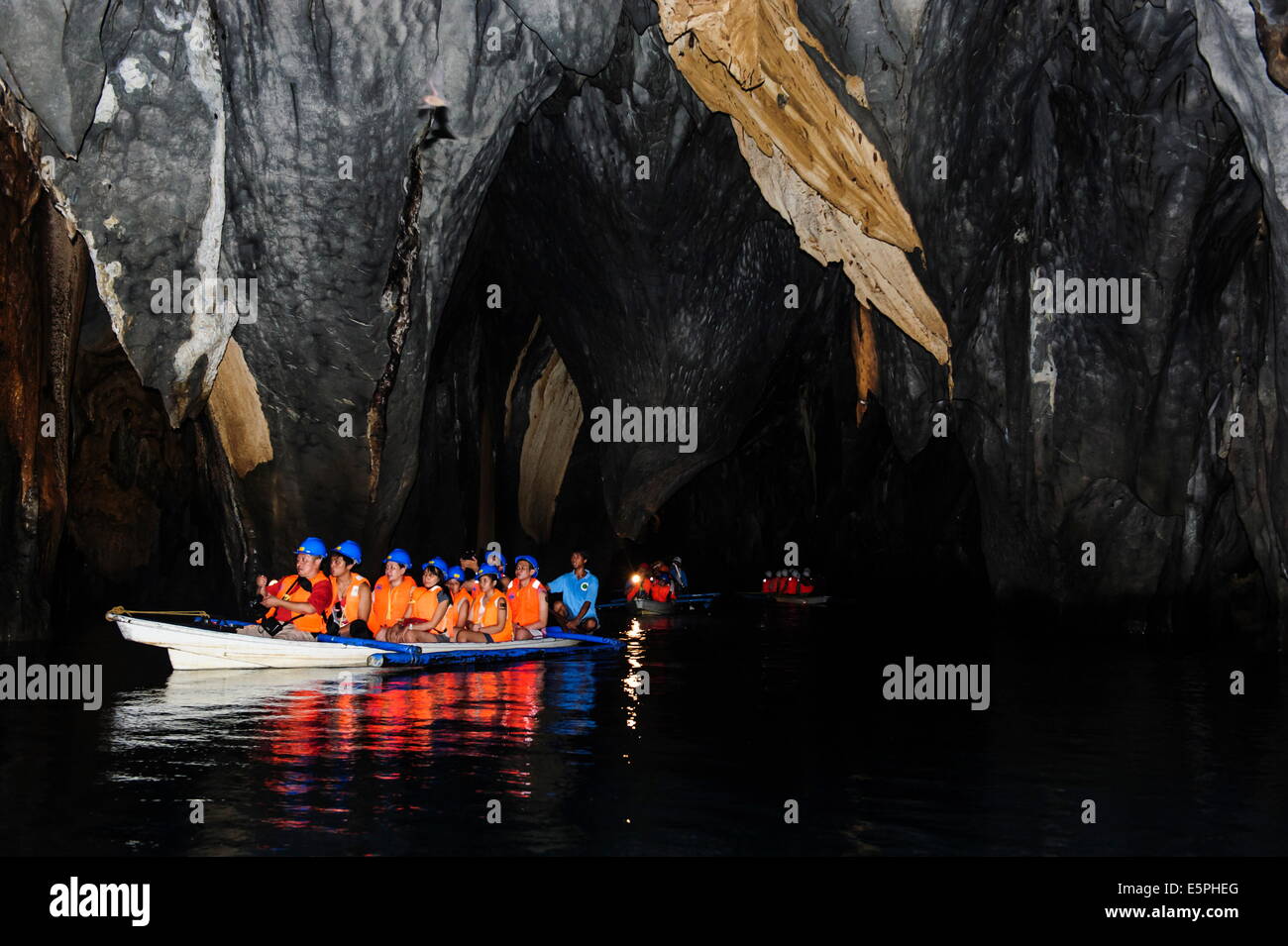 Los turistas en un bote de remos entrando en el río subterráneo, el Parque Nacional Río Puerto-Princesa, sitio UNESCO, Filipinas Foto de stock