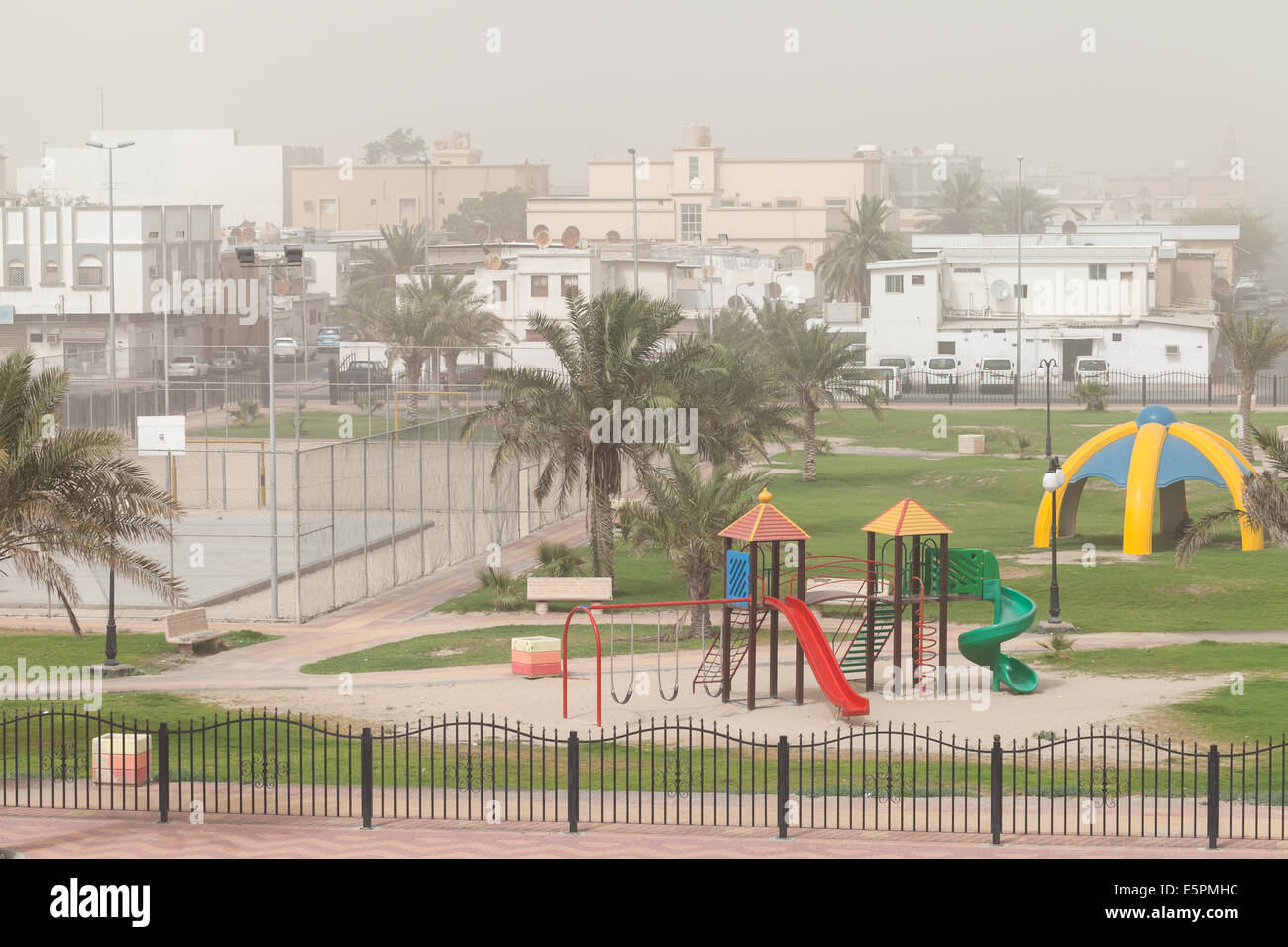 Tormenta de polvo. Patio con palmeras, Arabia Saudita Foto de stock