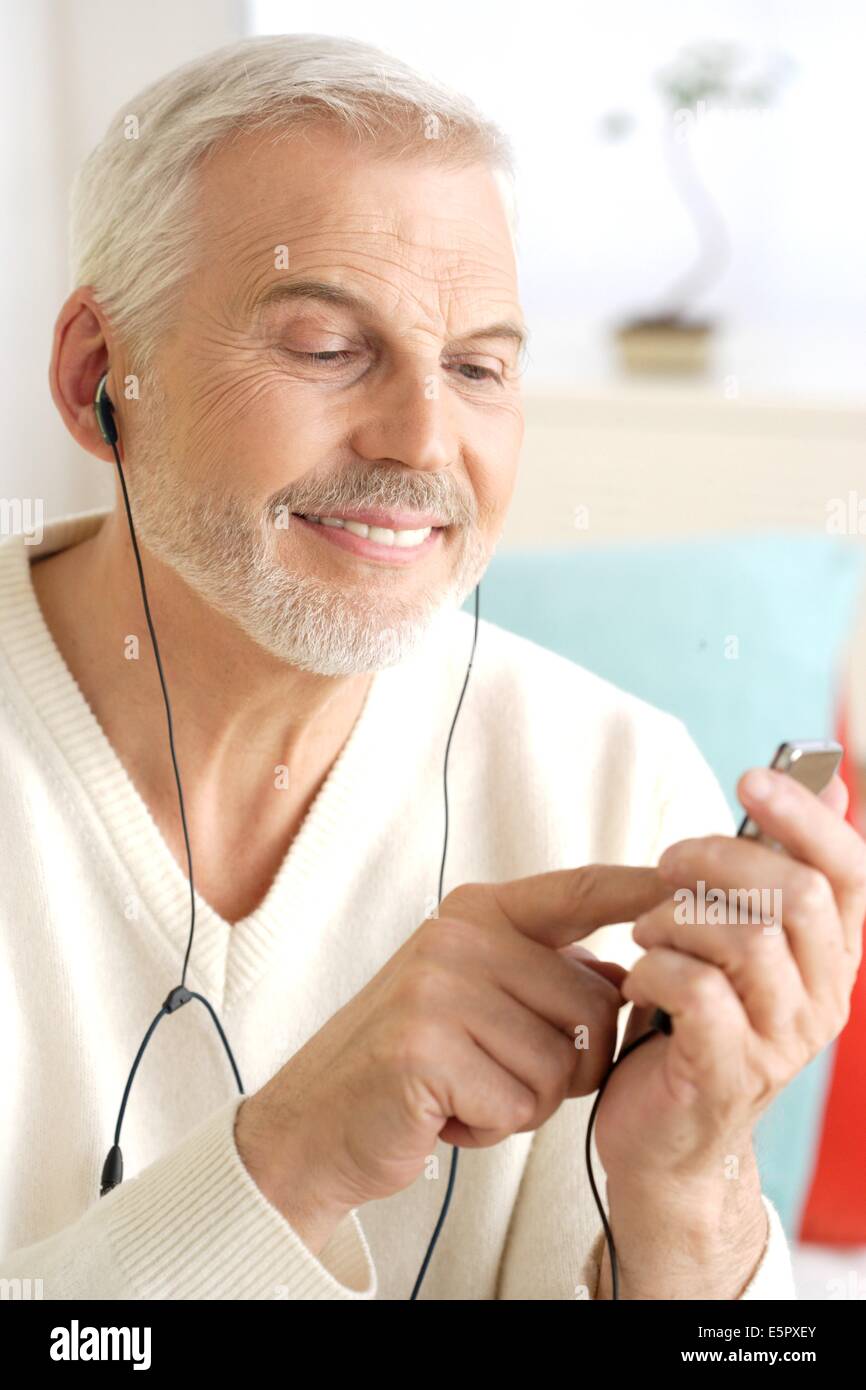 El hombre escuchando música con un reproductor de MP3. Foto de stock