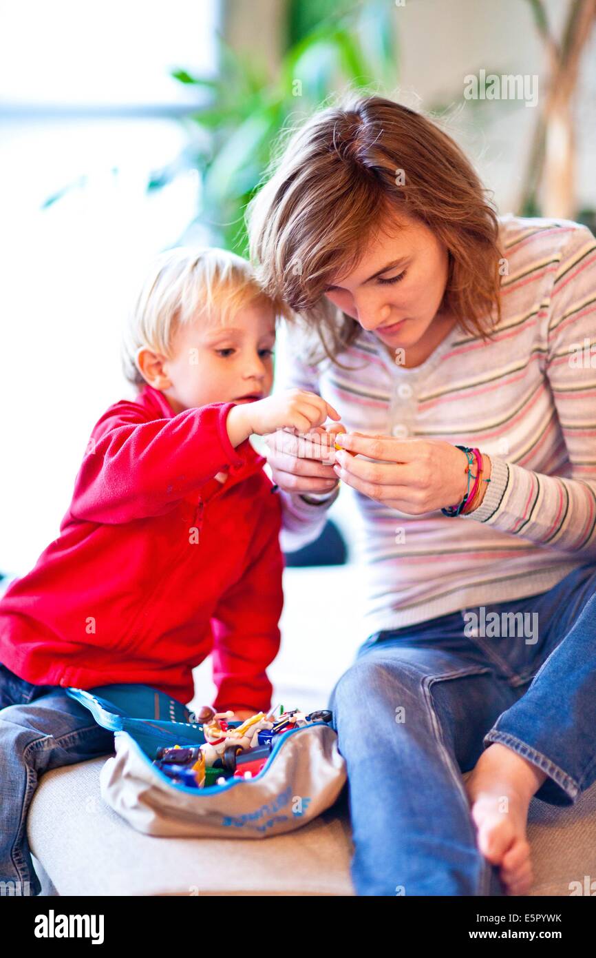 Adolescente y niño de 3 años jugando con figuritas. Foto de stock
