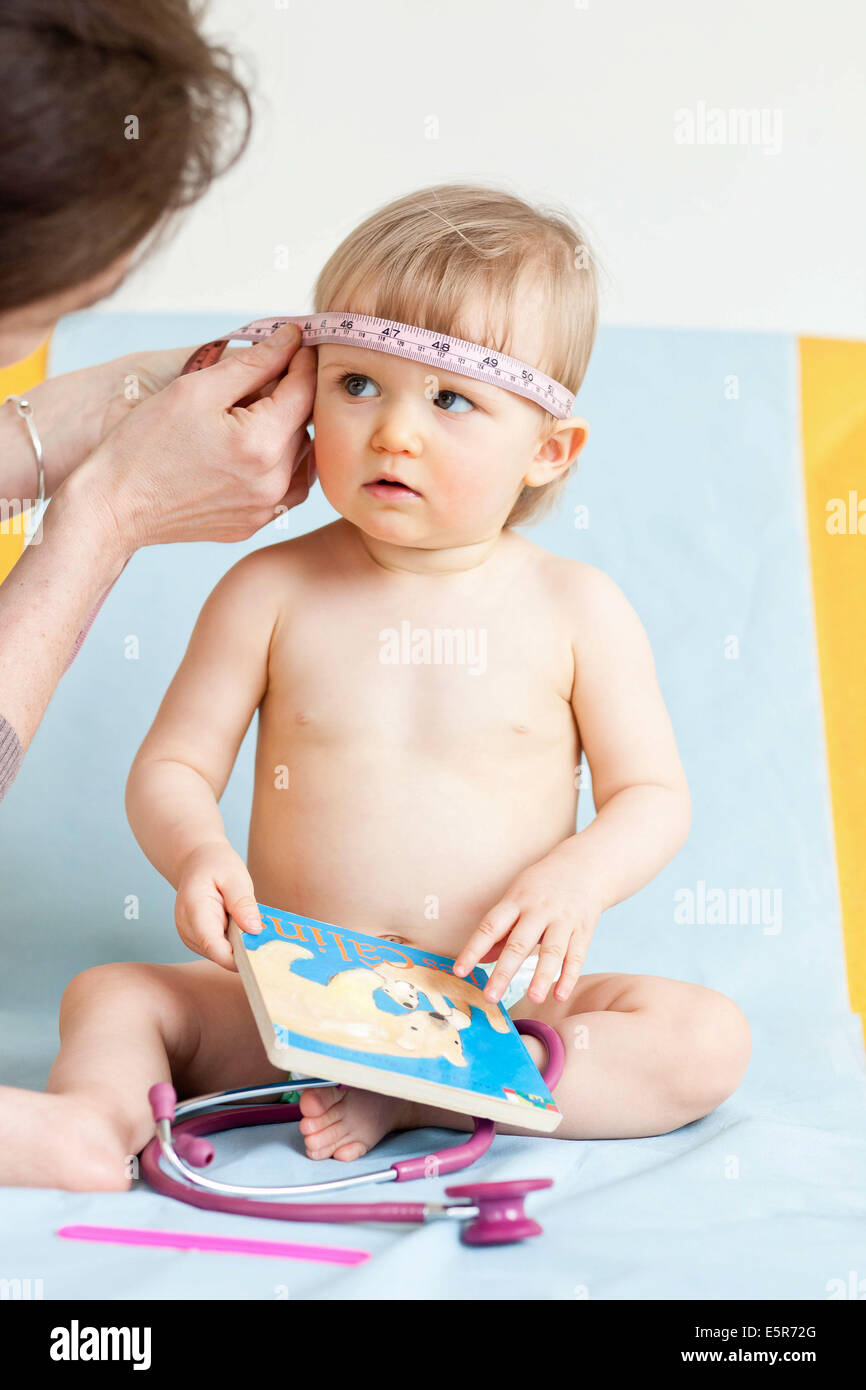 Medición de la circunferencia de 14 meses de edad, la cabeza del bebé ( perímetro craneal) con una cinta métrica Fotografía de stock - Alamy
