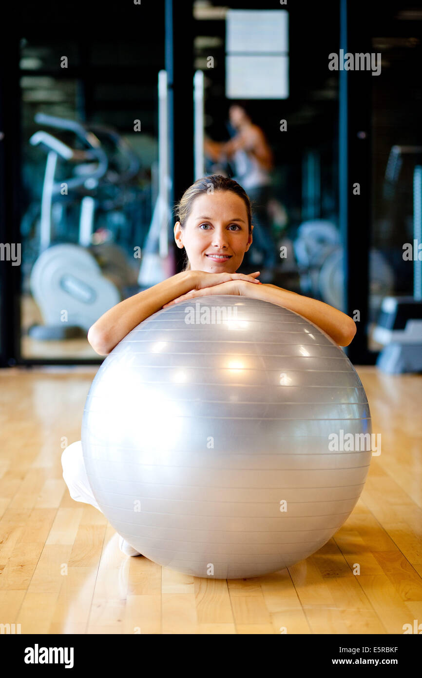 Mujer con bola de ejercicios en un gimnasio. Foto de stock