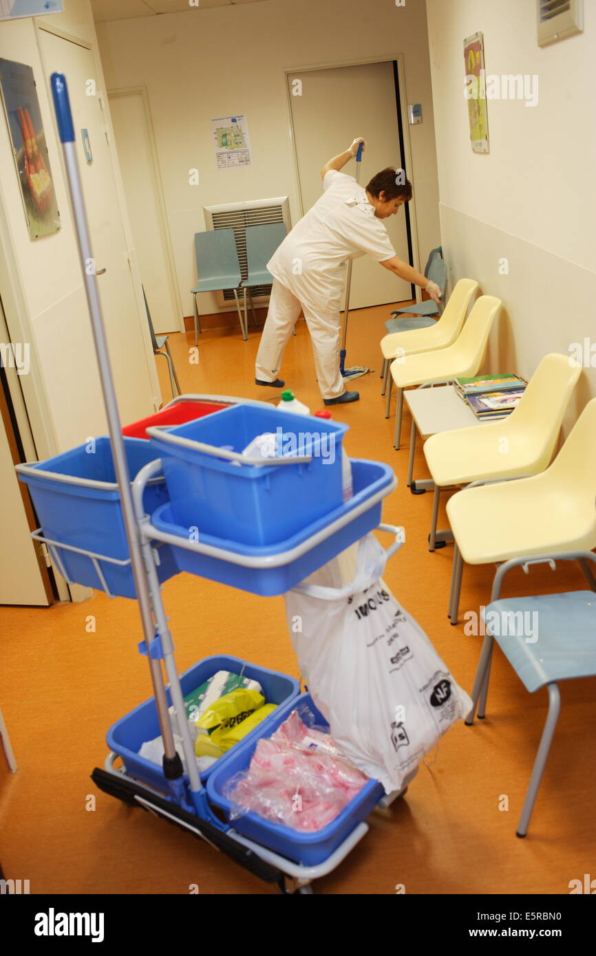 Cuidan la limpieza de la sala de espera del hospital después de tiempo de consulta. Foto de stock