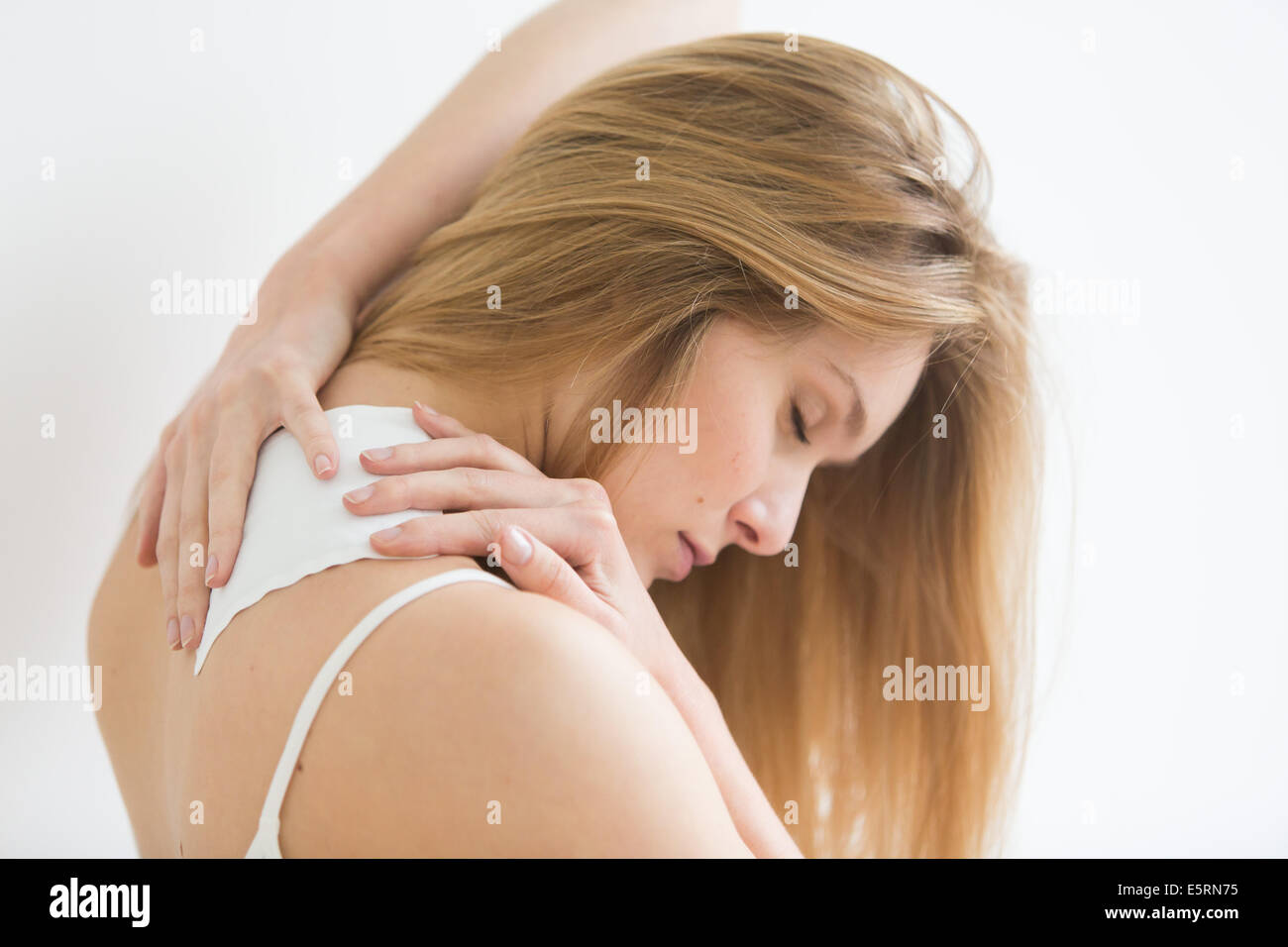 Mujer aplicando calor, parche para el dolor de espalda. Foto de stock