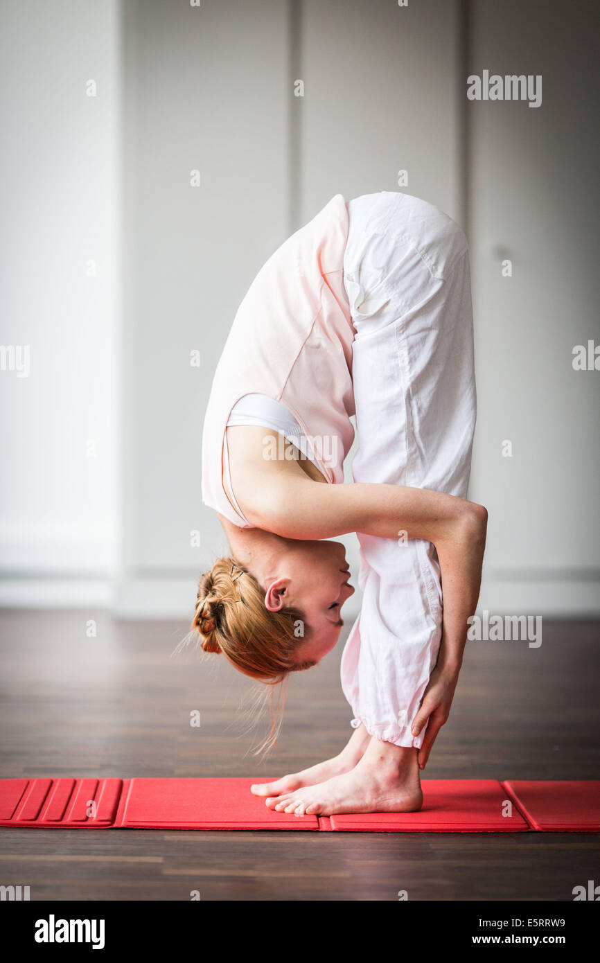 Mujer practicar ejercicios de estiramiento para aliviar el dolor de espalda. Foto de stock