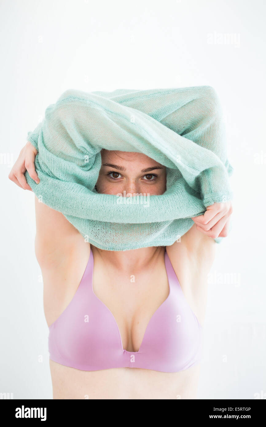 Mujer joven despegando su jersey Fotografía de stock - Alamy