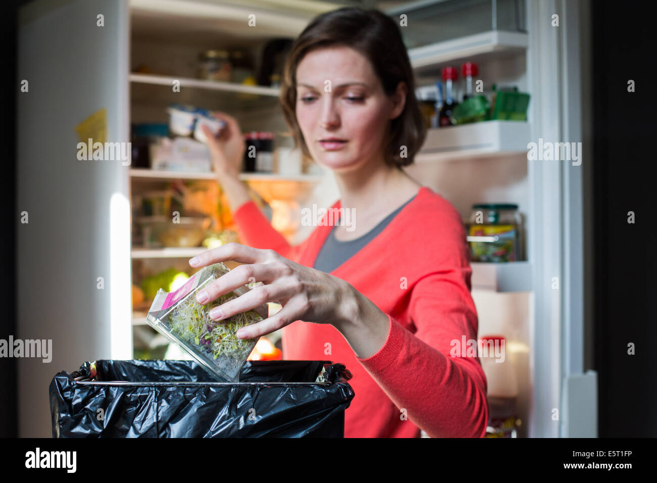 Mujer tirando la comida a la basura Fotografía de stock Alamy