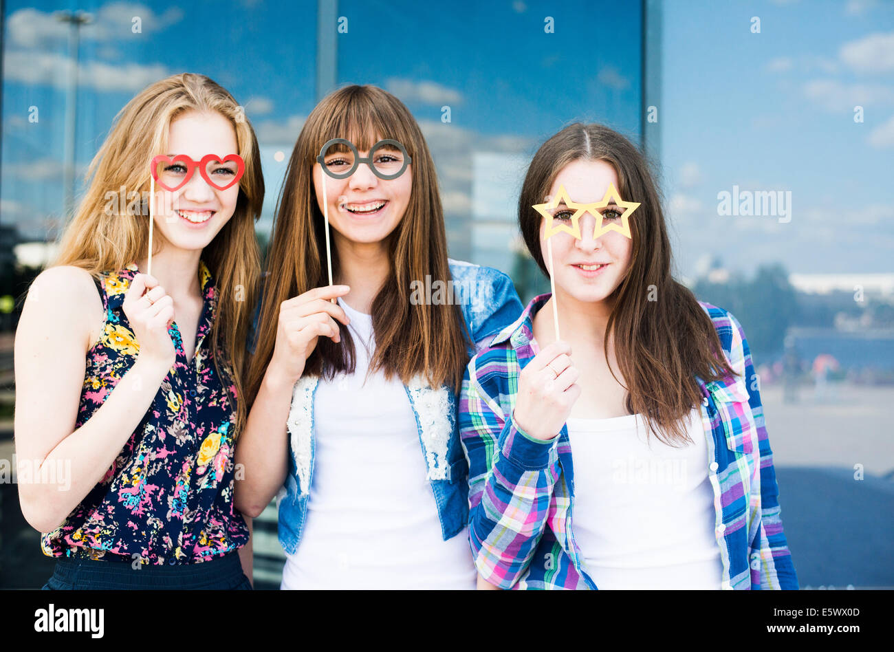 Retrato de tres jóvenes mujeres sosteniendo espectáculo Máscaras Vestuario Foto de stock