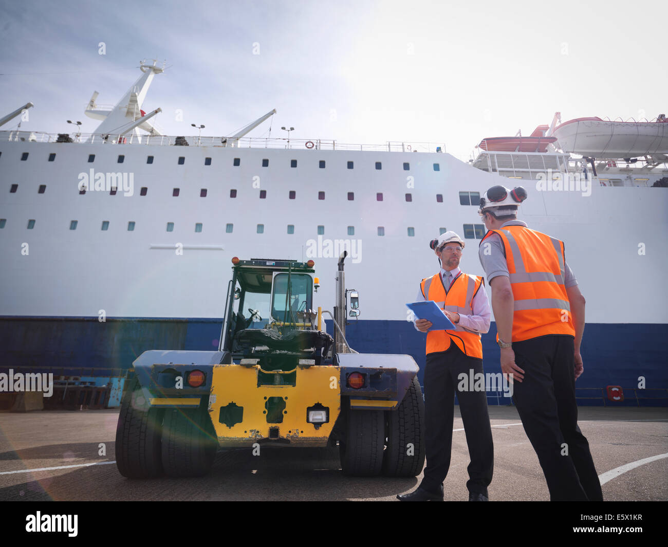 Los trabajadores portuarios, transporte camión contenedor y el buque en el puerto Foto de stock