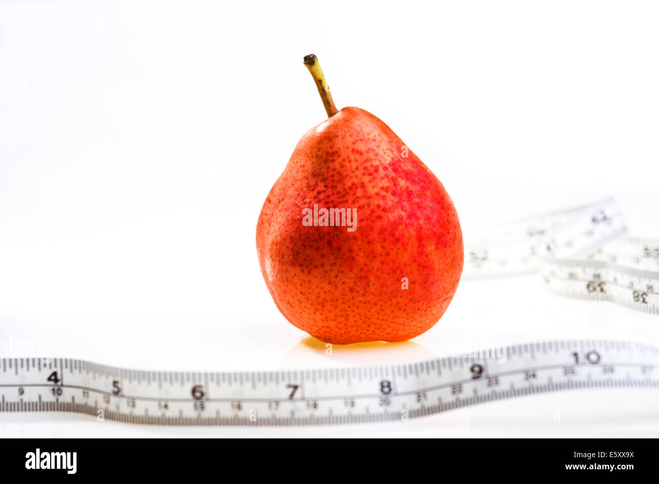 Pera roja con cinta métrica.La obesidad, pérdida de peso, la dieta. Foto de stock