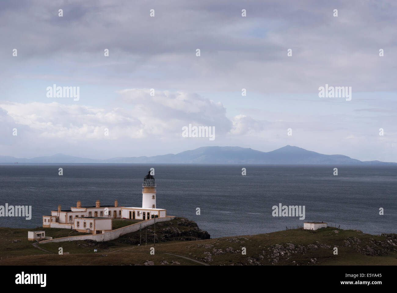 Neist Point faro en la Isla de Skye con Benbecula y South Uist en el fondo a través de la poco Minch Foto de stock