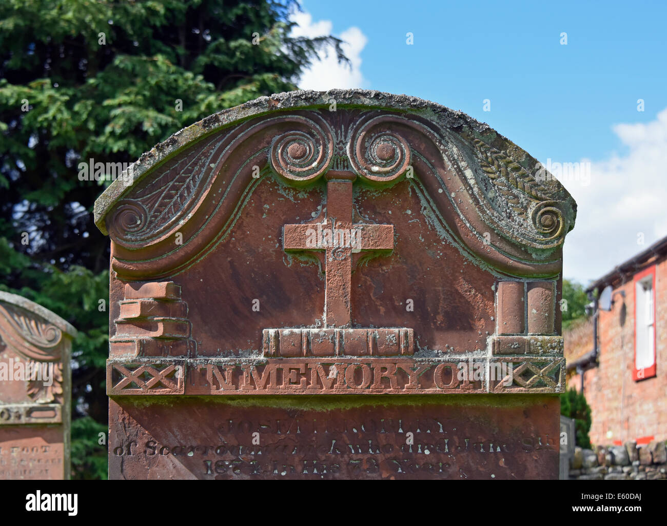 Lápidas de piedra arenisca con cruz y diseño de libros. Iglesia de San Juan Bautista. Croglin, Cumbria, Inglaterra, Reino Unido. Foto de stock