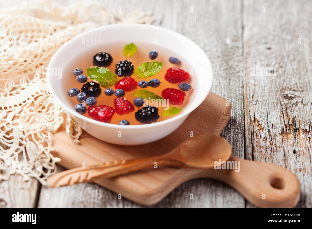 Sopa de frutas con frambuesa, arándano, mora y menta Foto de stock