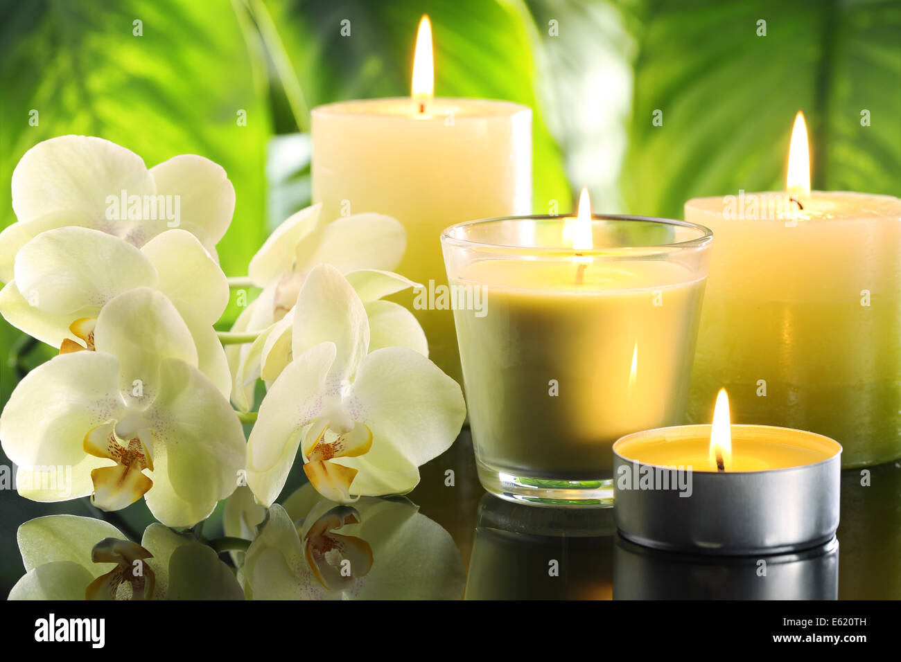 Spa bodegón con velas encendidas y flor de orquídea Foto de stock